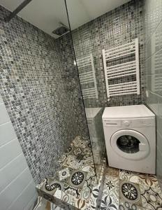 uma cabina de duche com uma máquina de lavar roupa na casa de banho em Big and comfortable apartment em Chisinau