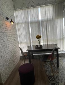 una mesa con una flor delante de una ventana en Big and comfortable apartment en Chisináu