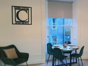 een eetkamer met een tafel en stoelen en een raam bij Crown Central Apartments in Aberdeen