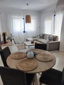 sala de estar con mesa de madera y sillas en Marina Gardens, en Pafos