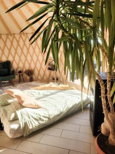 a bedroom with a bed in a yurt with a plant at Hoya Glamping in Gostynin