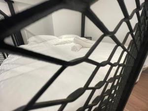 a black cage with a bed with white sheets at The Magazine Boutique Hotel in George Town