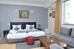 カサブランカにあるEAST WEST HOTELのベッドとソファ付きのホテルルーム