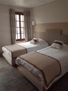 two beds in a bedroom with a window at Au Lion d'or in Saint-Pol-sur-Ternoise