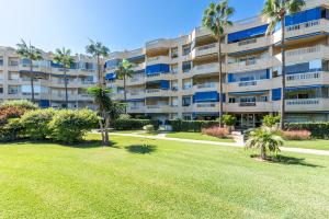 een groot appartementencomplex met palmbomen en een tuin bij Costa Lago Playa in Torremolinos