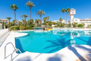 een groot zwembad met palmbomen op de achtergrond bij Costa Lago Playa in Torremolinos