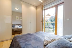 a bedroom with a bed and a large window at Pod Tatrami in Zakopane