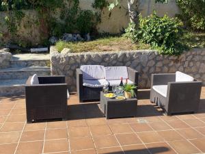 three wicker chairs and a table on a patio at Villa Sitges Soledad 15 minutes drive from Sitges XXL swimming pool 12 p in Olivella