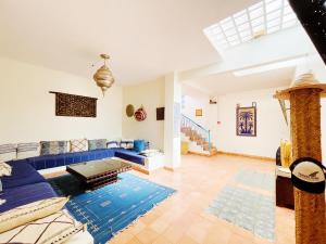 a living room with a blue couch and a blue rug at La Paix Hôtel , Restaurant in Taghazout