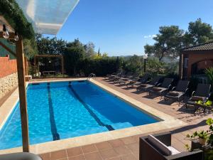 a swimming pool with lounge chairs next to it at Villa Sitges Soledad 15 minutes drive from Sitges XXL swimming pool 12 p in Olivella