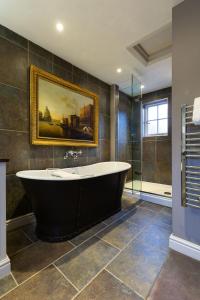 a bathroom with a tub and a painting on the wall at The Bildeston Crown in Bildeston