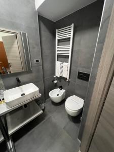 a bathroom with a sink and a toilet and a mirror at Hotel Ferrucci in Turin