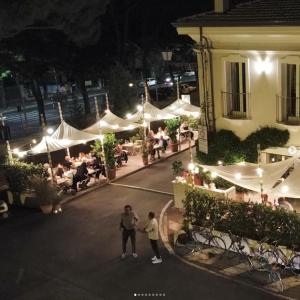 a group of people standing outside of a building at night at Sasaràl Suites in Cesena