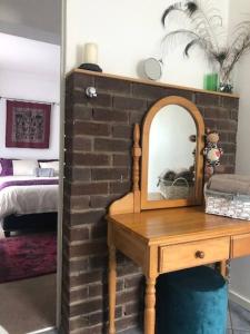 a brick wall with a mirror on a wooden table at Welcoming One Bedroom Flatlet with Pool in Pietermaritzburg