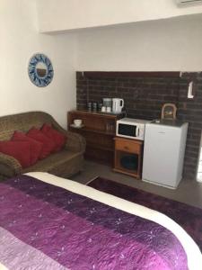 a living room with a couch and a kitchen at Welcoming One Bedroom Flatlet with Pool in Pietermaritzburg