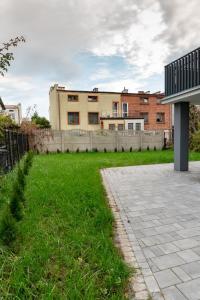 een grasveld met een gebouw op de achtergrond bij Miłe studio z ogródkiem i osobnym wejsciem in Radom