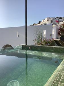 a swimming pool with blue water and white buildings at Riad Aziman in Tetouan