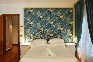 a bedroom with a large bed with a floral wallpaper at Venicegreen Agriresort in Tessera