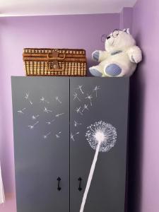 a teddy bear is sitting on top of a cabinet with a dandelion at Katie’s Cottage in Limerick