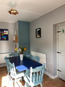 a dining room with a blue table and chairs at Katie’s Cottage in Limerick