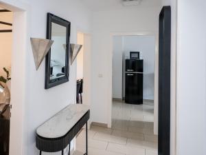 d'un miroir et d'un banc dans le couloir avec un réfrigérateur. dans l'établissement Exklusive und gemütliche Unterkünfte in Krefeld - JUNIK Apartments, à Krefeld