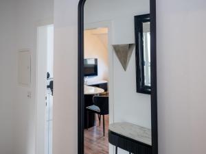 un miroir en face d'une chambre avec une table dans l'établissement Exklusive und gemütliche Unterkünfte in Krefeld - JUNIK Apartments, à Krefeld