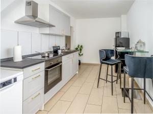 a kitchen with white cabinets and a table with chairs at Gemütliche & Individuelle Ferienwohnungen in Krefeld - JUNIK Apartments in Krefeld