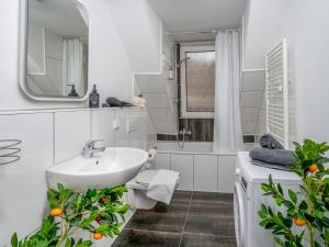 La salle de bains est pourvue d'un lavabo, de toilettes et d'un miroir. dans l'établissement Exklusive und gemütliche Unterkünfte in Krefeld - JUNIK Apartments, à Krefeld