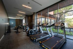 a gym with several cardio machines in a building at VELA DHI Nakhon Phanom in Nakhon Phanom