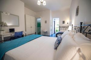 a bedroom with a large white bed and a desk at Sonnino B&B in Procida