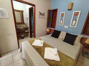 a bedroom with a large bed with two towels on it at Pousada Recanto da Grande Paz in Alto Paraíso de Goiás