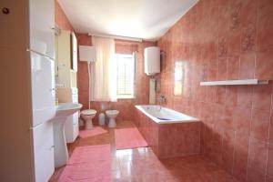 łazienka z wanną, umywalką i toaletą w obiekcie Apartment Potnar M w mieście Malinska +6 zdjęć