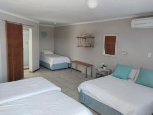 ein Hotelzimmer mit 2 Betten und einem Tisch in der Unterkunft Grunau Country Hotel in Grünau
