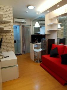 a living room with a red couch and a desk at Apartemen Bassura City by Globy Property in Jakarta