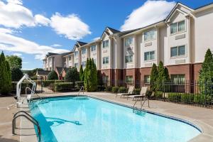 a swimming pool in front of a apartment building at Microtel Inn & Suites by Wyndham Woodstock/Atlanta North in Woodstock