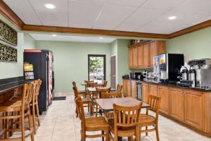 a restaurant with tables and chairs and a kitchen at Microtel Inn & Suites by Wyndham Woodstock/Atlanta North in Woodstock