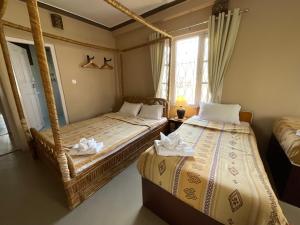 博卡拉New Hotel Castle的有两张床和一扇窗户的卧室