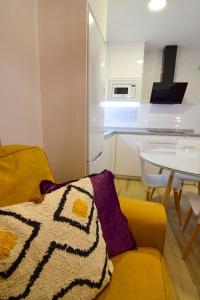 a living room with a yellow couch and a table at Letmalaga Square Merced in Málaga