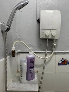 a bathroom with a shower head and a bottle of lotion at Homestay Malim Nawar in Malim Nawar