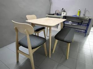 una mesa de madera y 2 sillas en la cocina en Homestay Malim Nawar, en Malim Nawar