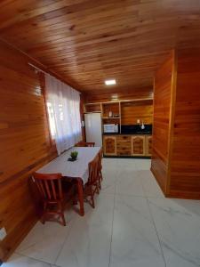 ein Esszimmer mit einem Tisch und Holzwänden in der Unterkunft Águia Dourada Hospedagem Casa 01 in Bom Jardim da Serra