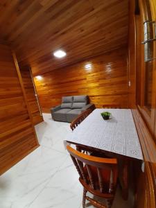 ein Wohnzimmer mit einem Tisch und einem Sofa in der Unterkunft Águia Dourada Hospedagem Casa 01 in Bom Jardim da Serra