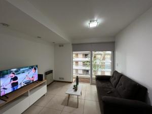 un salon avec un canapé et une télévision à écran plat dans l'établissement Lourdes, à Rosario