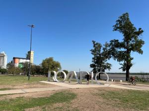 una persona de pie junto a una escultura en un parque en Lourdes en Rosario