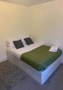 ロンドンにあるBalham, South London Spacious Guest House 3のベッドルーム1室(緑の毛布、電話付)