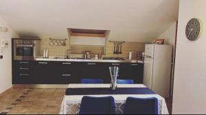 a kitchen with a table with blue chairs and a refrigerator at La dimora di Mara in Mercogliano +4 photos