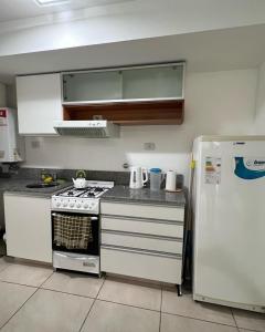 une cuisine avec une cuisinière et un réfrigérateur dans l'établissement Lourdes, à Rosario