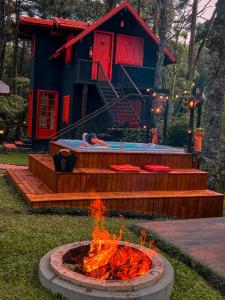 a fire pit in front of a log cabin at Pousada Vila 505 in Canela