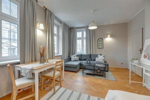 a living room with a table and a couch at Downtown Apartments Old Town Chlebnicka in Gdańsk