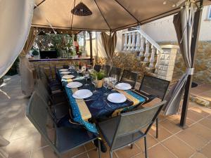 a long table with chairs and plates on it at Villa Sitges Ilusión 15 minutes by car from Sitges Sleeps 16 people XXL swimming pool in Olivella